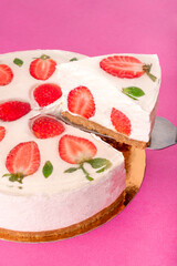Strawberry cake with white cream on biscuits base on pink background