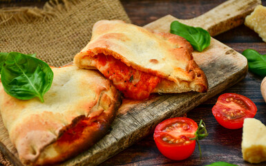 Home made italian calzone vegetarian  pizza with  tomatoes, mozzarella and parmesan cheese and fresh basil 