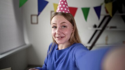 Caucasian blonde holds a phone in her hands and celebrates her birthday on the air. Blowing confetti off his hands. online remote party concept.