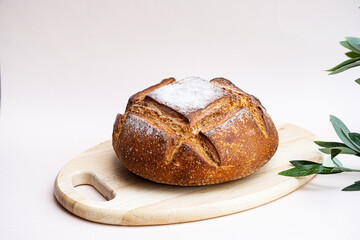 Loaf of homemade bread. Fresh baked on the wooden plate. Nutrition concept. Minimal still life