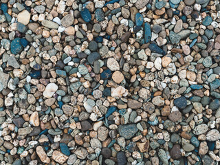 horizontal background: many small stones of different colors close-up