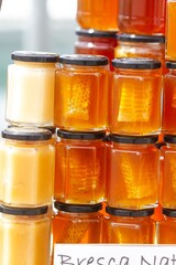 Stacked glass jars of fresh honey ready for sale, food concept.