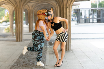 couple with dog and dinosaur masks, absurd and funny trend concept