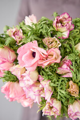 Beautiful bouquet of pink anemones in woman hand. the work of the florist at a flower shop. A small family business