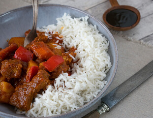 homemade cooked filipono spicy pork stew with vegetables, sauce and basmati rice