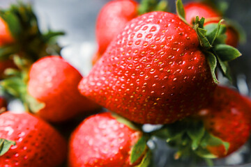 Plastic tray with fresh washed strawberry on a dark table surface. Produce product. Food industry. Selective focus