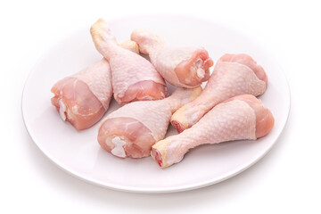 Raw chicken legs on a white plate 