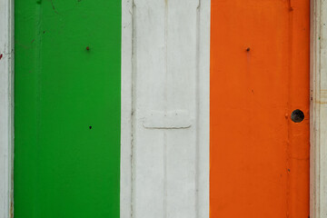 Old weathered door painted in colors of Irish National flag. Rich saturated colors. Expression of pride, love and patriotism to your country