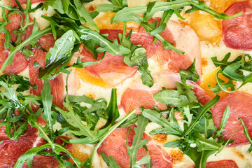 Italian pizza with carpaccio meat from wood-burning stove. lunch in an Italian restaurant. Table near to a large window.