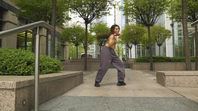 innfluential instagram famous dancer performing her moves in a small modern park outdoor London red bus passing through behind her slow motion