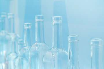 Glass bottles of different shapes and sizes on a light background. Blank for the designer. Close-up