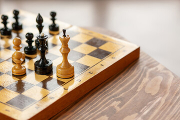 Wooden chess pieces on a board game, on vintage table, selective focus