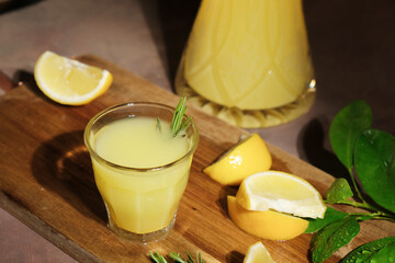 Alcoholic drink limoncello. Shot glass of Italian lemon liqour decorated rosemary, fresh lemons and...