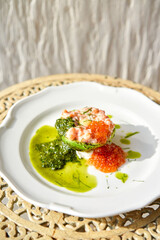 Raw salmon tartare. Fresh salmon, avocado and pesto sauce with red caviar on a plate. Selective focus
