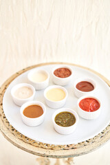 Sauces ketchup, mustard, mayonnaise, sour cream, soy sauce in clay bowls on table.