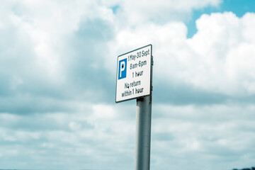 Car parking sign against sky