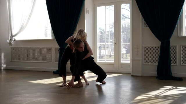 young pair of dancers are rehearsing in hall, contemporary choreography, woman and man are dancing