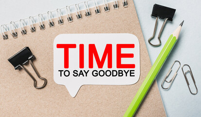 Text Time to Say Goodbye on a white sticker with office stationery background. Flat lay on...