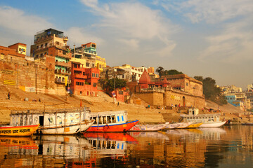 India, Varanasi Ganges river ghat with ancient city architecture as viewed from a boat on the river...