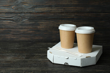 Pizza box and paper cups on wooden background