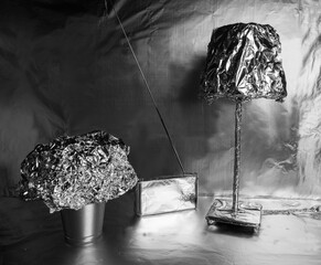 Iron home details. A radio and a plant pot on the table wrapped with aluminum foil.