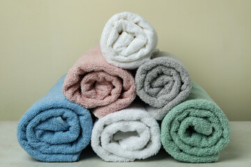 Obraz na płótnie Canvas Clean rolled towels against beige background, close up
