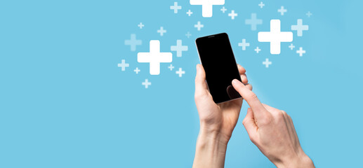 Male hand holding plus icon on blue background. Plus sign virtual means to offer positive thing like benefits, personal development, social network Profit,health insurance, growth concepts