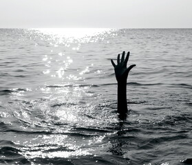 dramatic scene with the hand of the castaway who is about to drown in the middle of the ocean asking for help