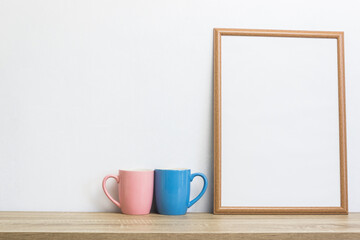 Coffee cups with photo frame on table.