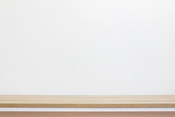 A white wall and a wooden table.