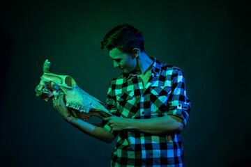 A young man dances in the studio with blue and green light