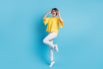 Full body photo of amazed brunette young woman look empty space hold glasses isolated on pastel blue color background
