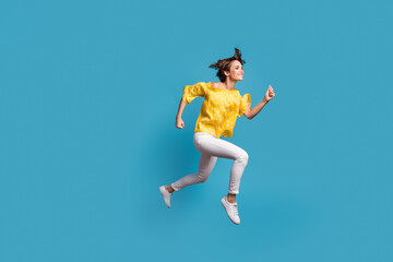 Fototapeta premium Full size profile side photo of attractive lady jump up air run empty space smile isolated on blue color background