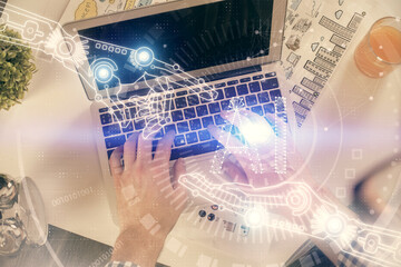 Multi exposure of man's hands typing over computer keyboard and data theme hologram drawing. Top view. Technology concept.