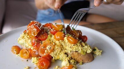 Vegan breakfast concept. Cutting healthy organic avocado toast topped with seeds and cherry tomatoes 