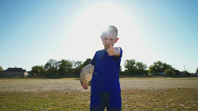 A member of the children's football team at the stadium under the scorching sun. Young player with the ball in his hand. The Goal defender prepares for the game. Football concept. 