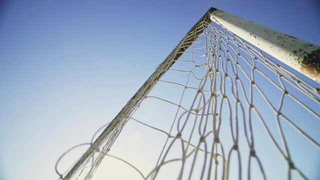 The ball hits the corner of the goal. The footballer scores a goal. Winning the championship. Football concept. Beautiful goal against the blue sky. Bottom view