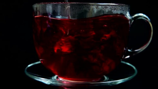 Preparation of Hibiscus tea in a glass cup.