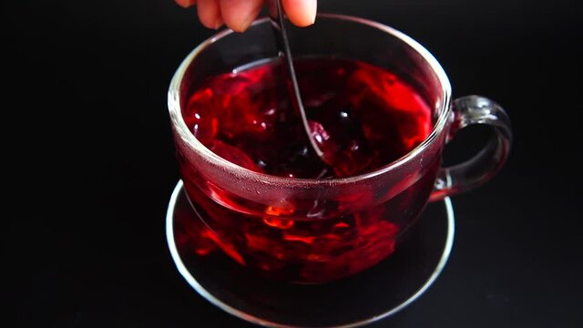 Preparation of Hibiscus tea in a glass cup.