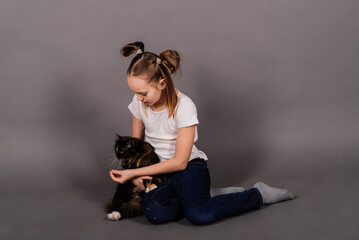 Fototapeta na wymiar Portrait of a little girl playing with her pet, black big cat
