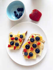 delicious toast for breakfast with buttercream, cheese and strawberries and blueberries. food photos