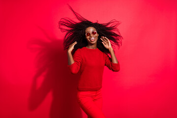 Portrait of attractive cheerful girl posing wind blowing hair good mood party isolated over bright red color background