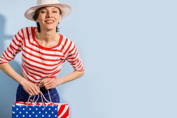 Happy shopping woman with shopping bags over blue background wearing striped clothing and shoping...