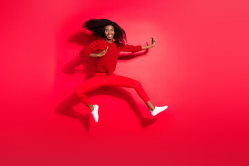 Fototapeta na wymiar Full body photo of young brunette cheerful woman jump up air fight smile isolated on red color background