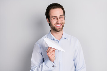 Portrait of attractive trendy cheerful man expert agent broker holding in hand paper plane isolated over grey pastel color background