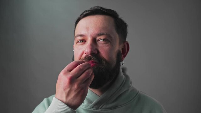 Slow motion Close-up of handsome bearded man with a gesture showing that he liked the treat