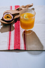 A glass of mango nectar with a slice of lime and cut passion fruit