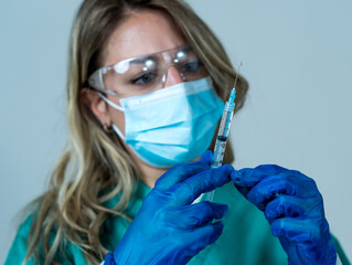 Female doctor or nurse holding COVID-19 Vaccine. Coronavirus medical treatment.