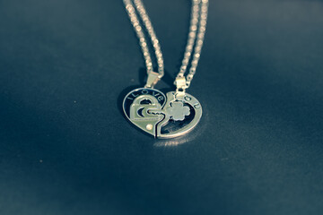 Couple set pendant necklace half of heart shoot outdoors in a sunny day closeup. Selective focus. High quality photo