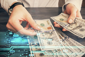 Double exposure of technology drawing hologram and us dollars bills and man hands. Data concept